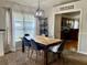 Dining area with a rustic wooden table, modern light fixture, and access to the kitchen at 1790 Turtle Rock Dr, Lakeland, FL 33803