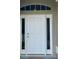 A close-up view of the white front door with side windows, enhancing curb appeal and natural light at 1790 Turtle Rock Dr, Lakeland, FL 33803