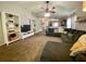 Carpeted living room featuring a large sofa, ceiling fan, and white shelving unit at 1790 Turtle Rock Dr, Lakeland, FL 33803