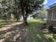 Scenic backyard featuring mature trees, manicured lawn, and partial views of a tranquil lake at 1805 S Lake Reedy Blvd, Frostproof, FL 33843
