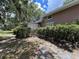 Charming single-story home featuring mature trees and landscaping with a covered porch and shuttered windows at 1805 S Lake Reedy Blvd, Frostproof, FL 33843