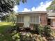 Home exterior features shuttered windows and a covered entryway framed by mature shrubs and lush greenery at 1805 S Lake Reedy Blvd, Frostproof, FL 33843