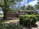 Single-story home surrounded by mature landscaping, offering a private outdoor space with shuttered windows and siding at 1805 S Lake Reedy Blvd, Frostproof, FL 33843