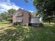 Side view of home exhibiting shuttered windows and a sprawling lawn beneath a canopy of mature trees at 1805 S Lake Reedy Blvd, Frostproof, FL 33843