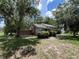 Quaint home exterior with mature trees and shrubbery, offering a serene and private setting at 1805 S Lake Reedy Blvd, Frostproof, FL 33843