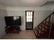 Living room with television, staircase, and door leading outside at 1805 S Lake Reedy Blvd, Frostproof, FL 33843