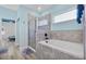 Bathroom with tub/shower combo, gray tiling, and a nearby window at 185 St Thomas Dr, Mulberry, FL 33860