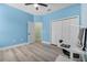 Bedroom featuring a fan, light blue walls, a large closet and wood look floors at 185 St Thomas Dr, Mulberry, FL 33860