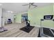 View of the exercise room featuring a treadmill and exercise bike adjacent to a desk, kitchen, and hallway at 185 St Thomas Dr, Mulberry, FL 33860