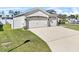 Exterior showcasing two car garage, well-manicured lawn, and fenced property line at 185 St Thomas Dr, Mulberry, FL 33860