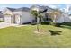 Charming home with a manicured lawn, featuring a palm tree and lush landscaping at 185 St Thomas Dr, Mulberry, FL 33860
