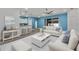 Inviting living room with bright blue walls, white sofas, and a view into the open kitchen at 185 St Thomas Dr, Mulberry, FL 33860
