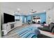 Open-concept living room with blue walls, a ceiling fan, modern entertainment center and bar seating at 185 St Thomas Dr, Mulberry, FL 33860