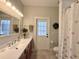 Light and bright bathroom features a large mirror, a single sink vanity and a toilet at 1976 Holy Cow Rd, Polk City, FL 33868
