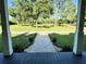 A brick walkway leads to a picturesque front yard with vibrant landscaping at 1976 Holy Cow Rd, Polk City, FL 33868