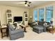 Bright living room features comfortable seating, large windows, and decorative shelving for a cozy atmosphere at 1976 Holy Cow Rd, Polk City, FL 33868