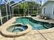 Screened-in pool area with an in-ground pool and an attached spa, surrounded by chairs at 1976 Holy Cow Rd, Polk City, FL 33868