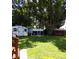 Spacious backyard features a large shade tree, storage shed, and a chicken coop at 2021 Oliver Pl, Winter Haven, FL 33881
