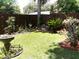 Landscaped backyard featuring decorative greenery, rock feature, and bird bath at 2021 Oliver Pl, Winter Haven, FL 33881