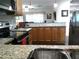 Inviting kitchen with granite counters, stainless appliances, wood cabinets and a pass-through view to the living room at 2021 Oliver Pl, Winter Haven, FL 33881