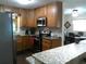 Updated kitchen with stainless steel appliances, granite countertops, and modern tile backsplash at 2021 Oliver Pl, Winter Haven, FL 33881
