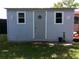Exterior view of the storage shed with a grey wood grain texture, small windows, and decorative accents at 2021 Oliver Pl, Winter Haven, FL 33881