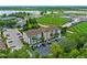 An attractive condominium building is shown in an aerial view, near a lush sports field, a lake, and ample parking at 2037 San Marcos Se Dr # 443, Winter Haven, FL 33880