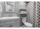 Clean bathroom featuring a modern vanity, floating shelves, and a shower with a stylish patterned curtain at 2037 San Marcos Se Dr # 443, Winter Haven, FL 33880