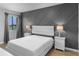 Comfortable bedroom with a white bed, matching nightstands, and a decorative wall, illuminated by natural light at 2037 San Marcos Se Dr # 443, Winter Haven, FL 33880