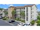 Exterior view of condo building with stone accents, balconies, well maintained landscaping and ample parking at 2037 San Marcos Se Dr # 443, Winter Haven, FL 33880