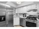 Updated kitchen with stainless steel appliances, white cabinetry, and a gas range for modern cooking at 2037 San Marcos Se Dr # 443, Winter Haven, FL 33880