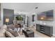 Bright living room featuring wood floors, large windows, modern furniture, and a stylish entertainment center at 2037 San Marcos Se Dr # 443, Winter Haven, FL 33880