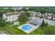 Aerial view of a community pool surrounded by lush landscaping, condos, and ample parking at 2037 San Marcos Se Dr # 443, Winter Haven, FL 33880