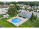 Aerial view of a community pool surrounded by lush landscaping, condos, and ample parking at 2037 San Marcos Se Dr # 443, Winter Haven, FL 33880