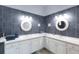 Bathroom with double sinks, white cabinets, granite counters and gray tiled walls at 209 Andros Ave # 15301, Davenport, FL 33897