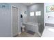 Well-lit bathroom featuring marble-walled tub and walk-in shower with glass enclosure at 209 Andros Ave # 15301, Davenport, FL 33897