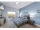 Bright bedroom with a ceiling fan, TV, and sliding glass doors to a balcony overlooking the landscape at 209 Andros Ave # 15301, Davenport, FL 33897