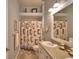 Neutral bathroom featuring a shower-tub with a patterned curtain, and a granite countertop sink at 2252 Fox Run Rd, Lake Wales, FL 33898