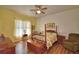 Charming bedroom with four poster bed, wood floors, and bright natural light at 2252 Fox Run Rd, Lake Wales, FL 33898