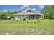 A single story ranch-style home with beige siding, a screened porch, and a well-manicured lawn at 2252 Fox Run Rd, Lake Wales, FL 33898