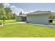 View of home's exterior with a large lawn, screened lanai and carport at 2252 Fox Run Rd, Lake Wales, FL 33898
