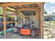 View of a covered shed with lawn equipment, including a Bad Boy riding mower at 2252 Fox Run Rd, Lake Wales, FL 33898