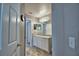 Well-lit bathroom featuring white cabinets, tile floors, and a mirror over the vanity sink at 2350 Paulette Dr, Haines City, FL 33844