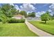 Well-manicured lawn leading to a community pool area enclosed by a white fence and mature landscaping at 2350 Paulette Dr, Haines City, FL 33844
