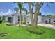 Charming home featuring a blue front door, well-kept lawn, and professional landscaping with mature trees at 2350 Paulette Dr, Haines City, FL 33844