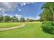 Scenic view of the golf course showcasing lush green fairways, mature trees, and community residences at 2350 Paulette Dr, Haines City, FL 33844