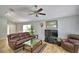 Open-concept living room with tile floors, comfortable leather seating, and a ceiling fan at 2350 Paulette Dr, Haines City, FL 33844