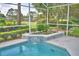 Inviting screened-in pool with colorful flower bed and water feature at 2350 Paulette Dr, Haines City, FL 33844