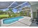 Screened-in pool area with clear blue water and a serene golf course view at 2350 Paulette Dr, Haines City, FL 33844