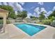 Sparkling community pool with a white fence, surrounded by lounge chairs and a shaded patio area at 2350 Paulette Dr, Haines City, FL 33844